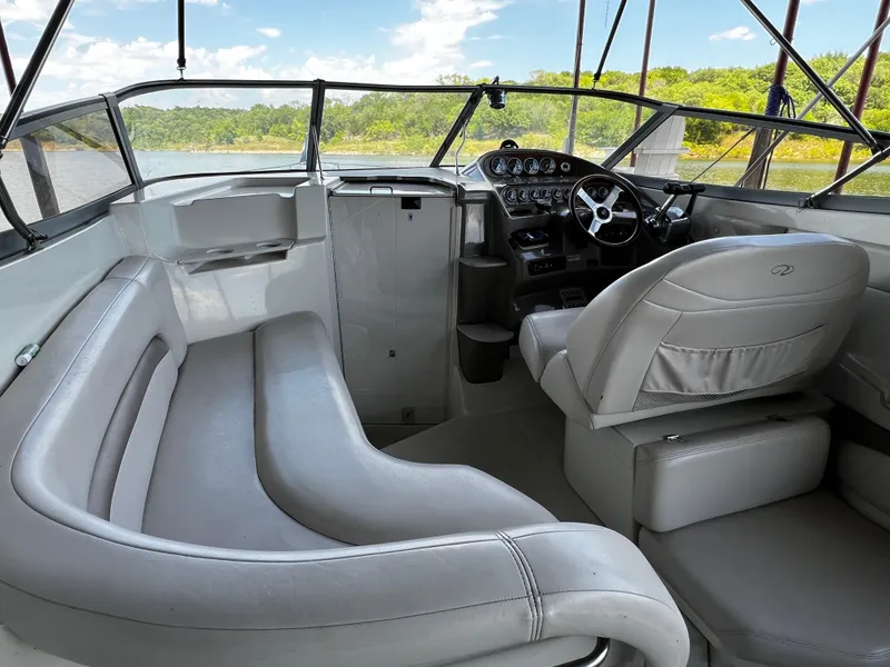 Slide: The Image of 1998 Regal Commodore 2760 boat interior with steering wheel and seating, overlooking a scenic water view. - 9