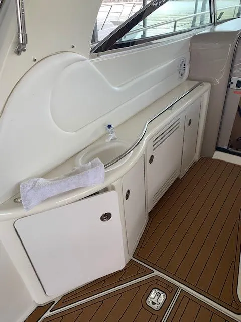 Slide: The Image of 2001 Sea Ray 380 Sundancer interior with white cabinetry and wood-patterned flooring. - 26