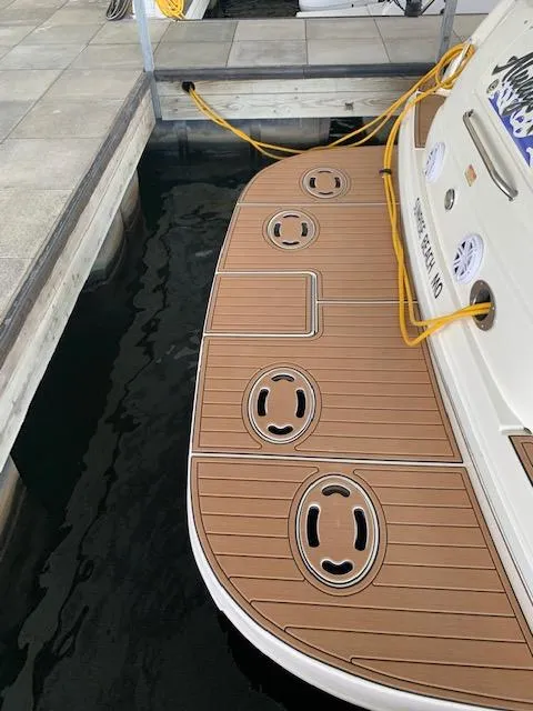 Slide: The Image of 2001 Sea Ray 380 Sundancer docked, showcasing teak swim platform and mooring lines. - 29