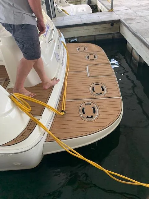 Slide: The Image of Man standing on 2001 Sea Ray 380 Sundancer boat deck at marina. - 32