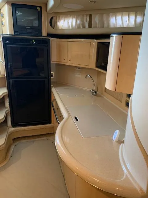 Slide: The Image of 2001 Sea Ray 380 Sundancer yacht interior with kitchenette, featuring cabinets and appliances. - 35