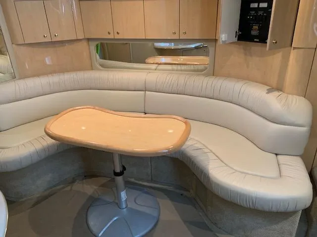 Slide: The Image of Luxurious interior of 2001 Sea Ray 380 Sundancer with curved seating and wooden table. - 37