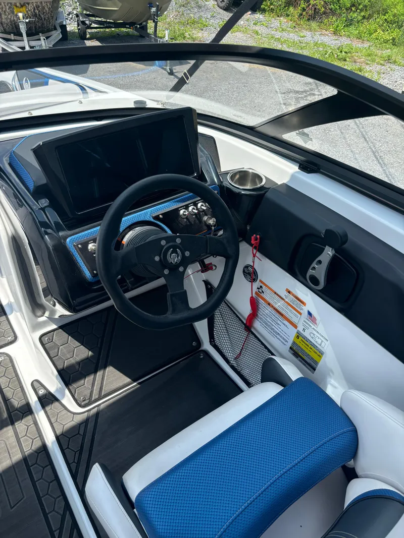 Slide: The Image of 2025 Scarab 195 H.O. boat cockpit with steering wheel and control panel. - 4