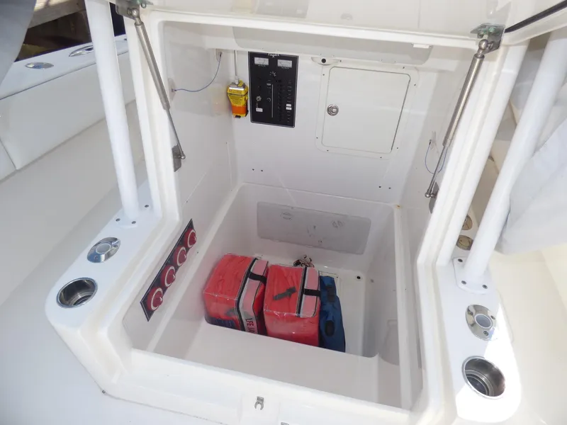 Slide: The Image of Open storage compartment on 2011 Invincible 36 CC boat with equipment and controls. - 10
