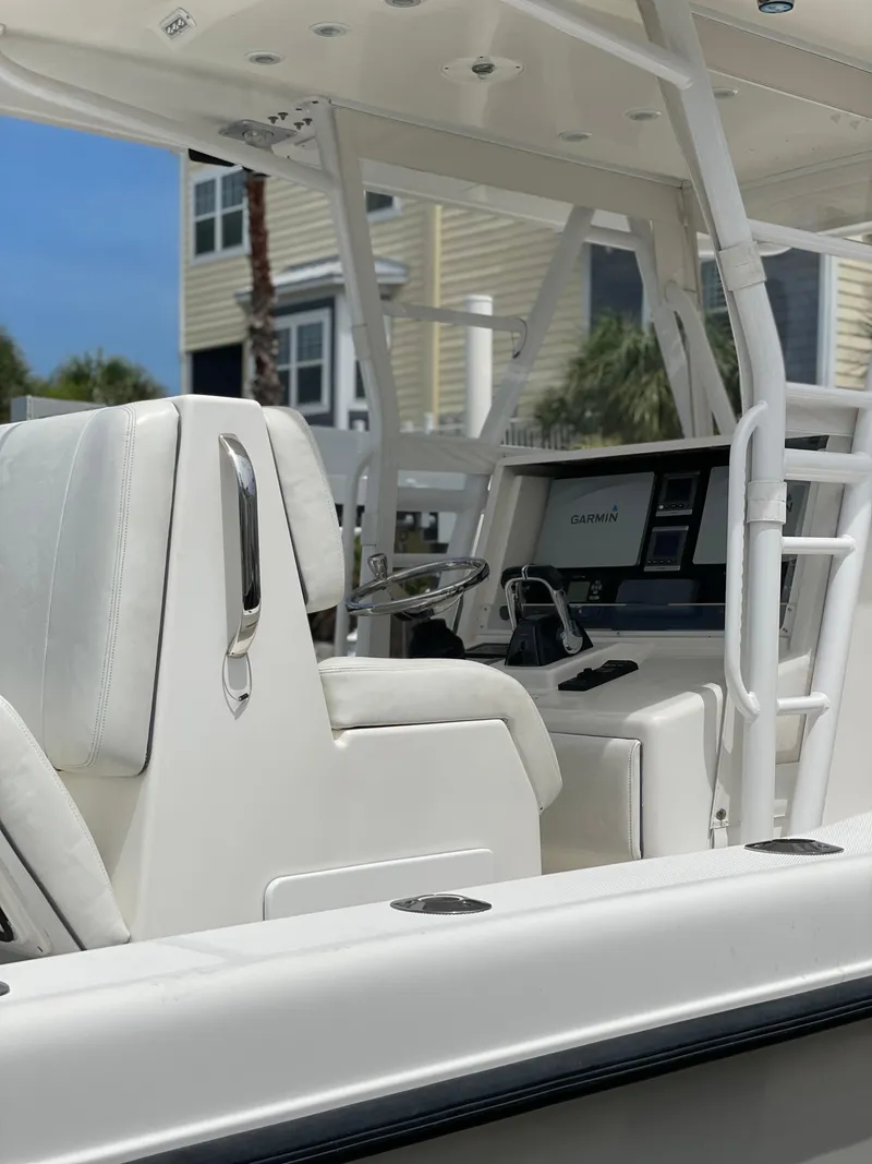 Slide: The Image of 2011 Invincible 36 CC boat interior with white seating and Garmin navigation system. - 14