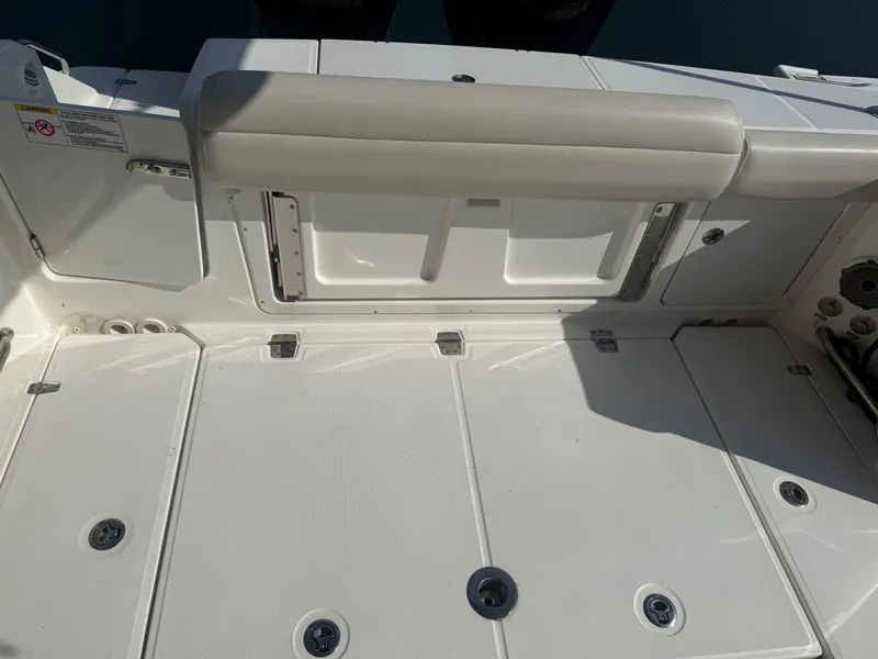 Slide: The Image of 2021 Boston Whaler 330 Outrage boat deck with seating and storage compartments. - 11