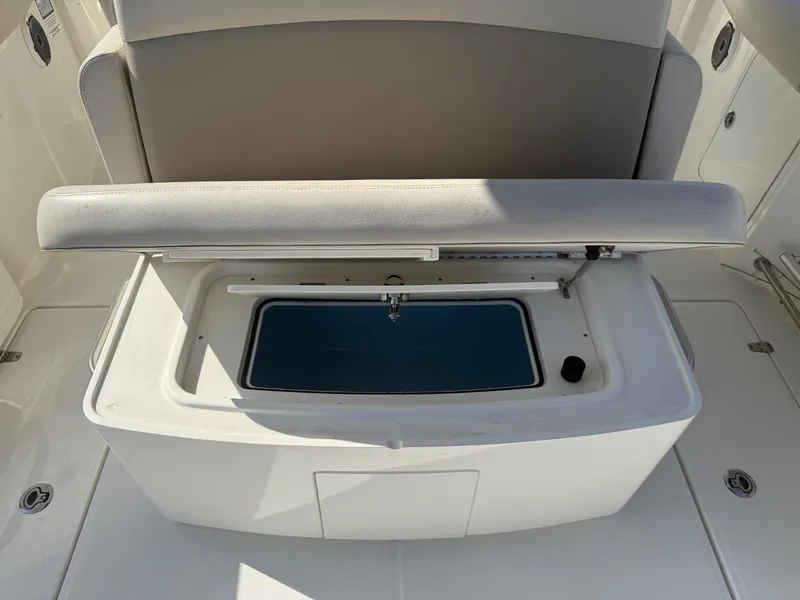Slide: The Image of 2021 Boston Whaler 330 Outrage boat seat with storage compartment open. - 14