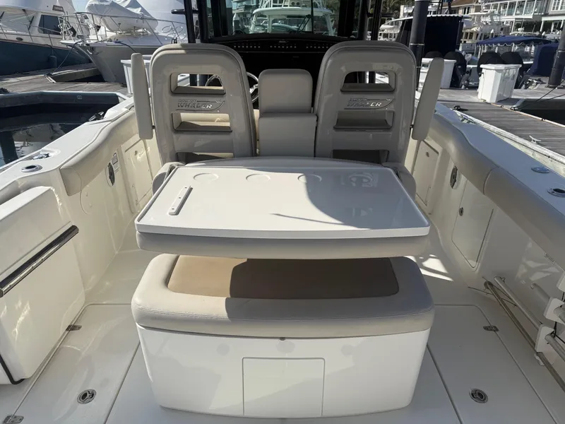 Slide: The Image of 2021 Boston Whaler 330 Outrage boat interior with seating and table setup. - 15