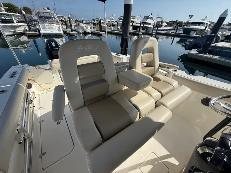 Slide: The Image of 2021 Boston Whaler 330 Outrage boat interior with luxurious seating at marina. - 16