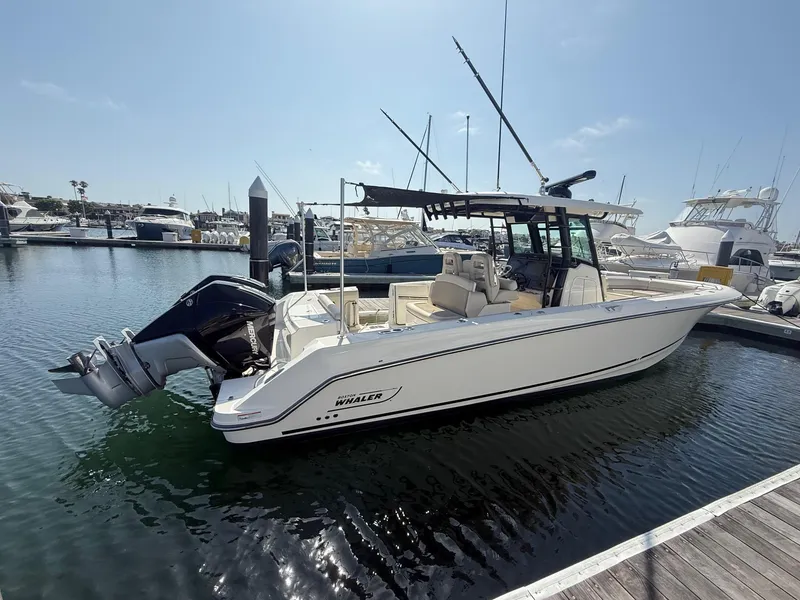 Slide: The Image of 2021 Boston Whaler 330 Outrage boat docked at marina, side view. - 2