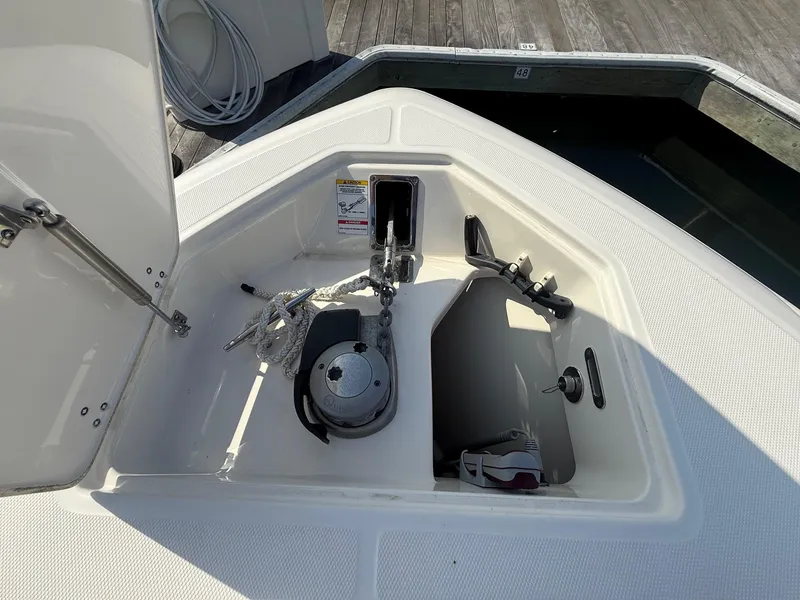 Slide: The Image of 2021 Boston Whaler 330 Outrage anchor locker with rope and winch. - 25