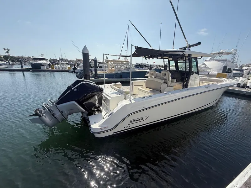 Slide: The Image of 2021 Boston Whaler 330 Outrage boat docked in a marina under clear skies. - 3