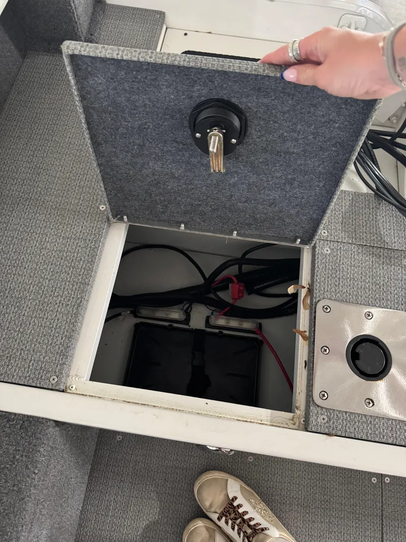 Slide: The Image of Open compartment on G3 AV17C Vinyl boat, revealing battery and wiring, 2024 model. - 6