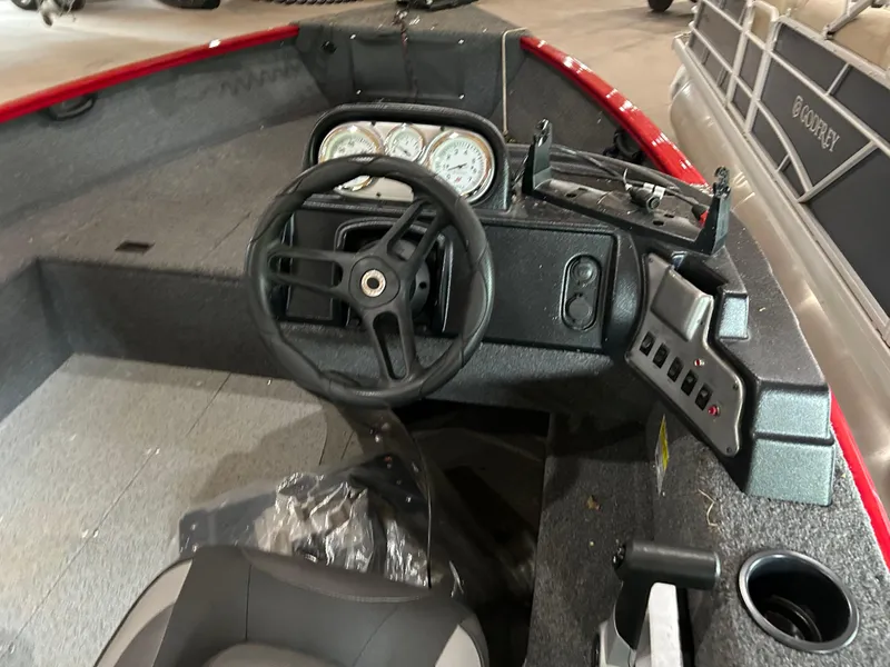 Slide: The Image of 2023 Lund 1650 Rebel XL Sport boat dashboard with steering wheel and control panel. - 4