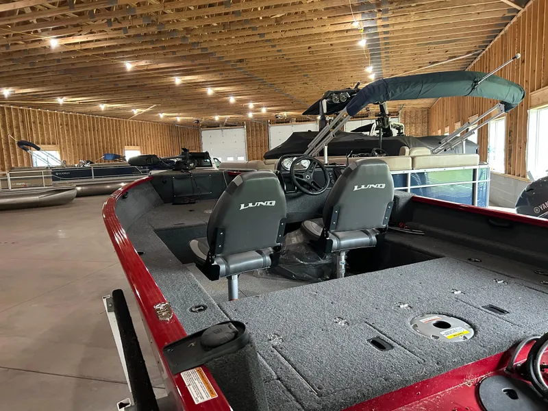 Slide: The Image of 2023 Lund 1650 Rebel XL Sport boat interior in a wooden storage facility. - 5