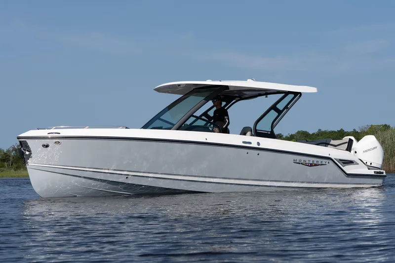 Slide: The Image of 2026 Monterey Elite 30 OB boat cruising on calm water under clear blue sky. - 4