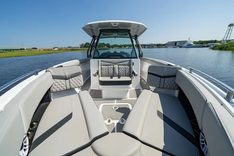 Slide: The Image of 2026 Monterey Elite 30 OB boat interior with luxurious seating on a calm waterway. - 8