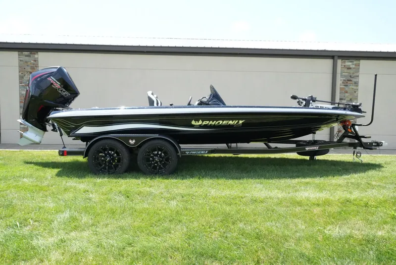 The Image of 2026 Phoenix 21 XE boat on trailer, black with green accents, parked on grass. - 1