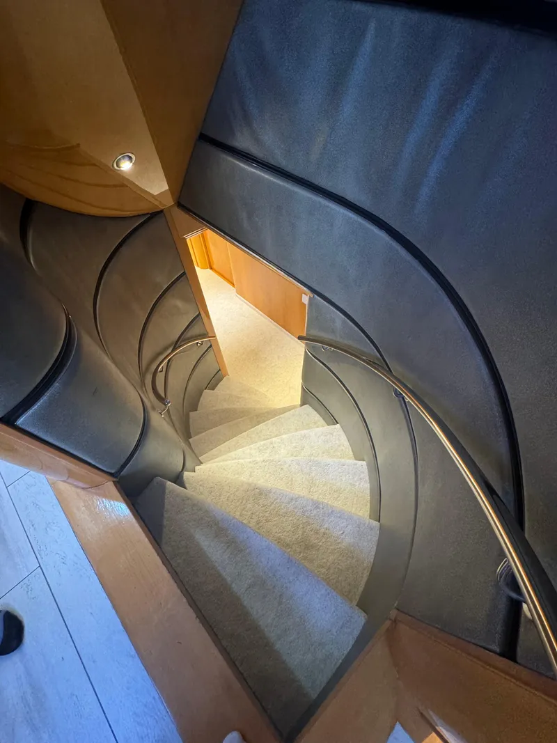 Slide: The Image of Spiral staircase inside 2000 Baglietto 116 yacht, featuring elegant wood and metal design. - 10
