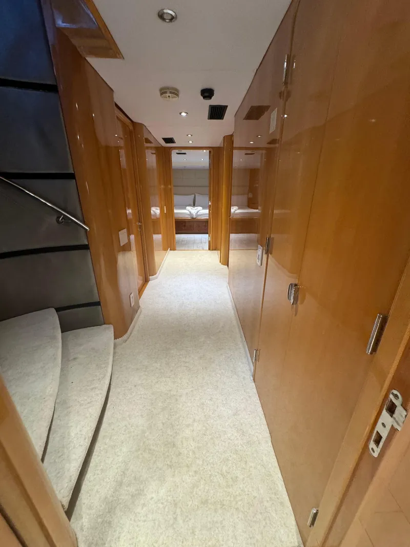 Slide: The Image of Luxurious hallway inside 2000 Baglietto 116 yacht, featuring wooden paneling and carpeted flooring. - 14