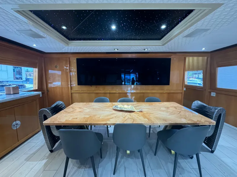 Slide: The Image of Luxurious dining area on 2000 Baglietto 116 yacht with elegant wood table and modern chairs. - 7