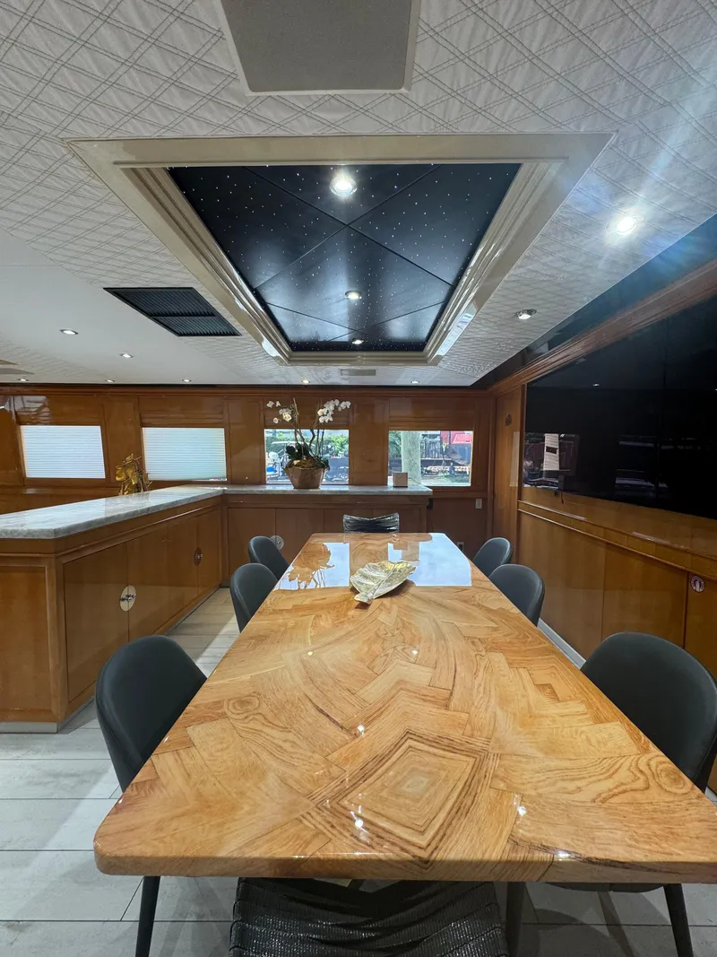 Slide: The Image of Luxurious interior of 2000 Baglietto 116 yacht with elegant dining area and wooden table. - 8