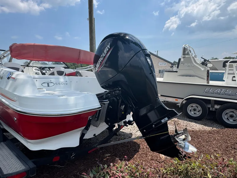 Slide: The Image of 2020 Tahoe 550TS boat with Mercury outboard motor, parked on a trailer under a blue sky. - 11