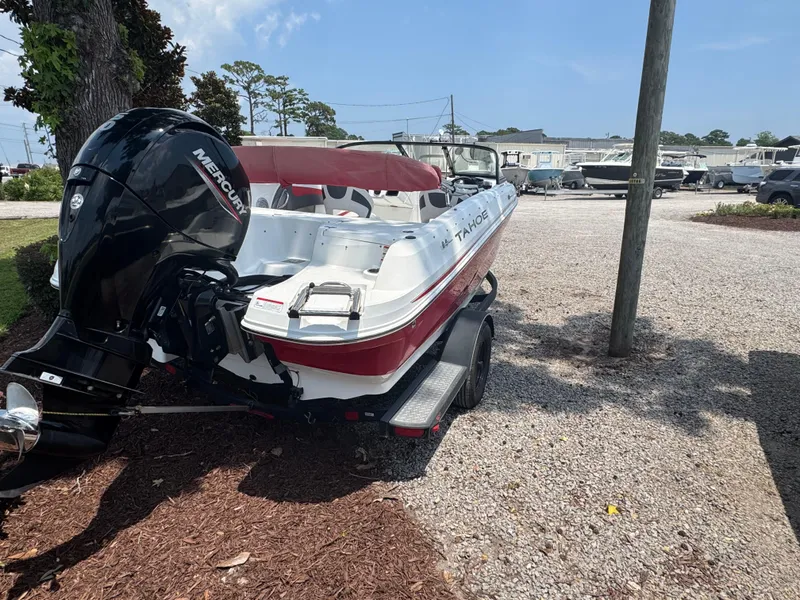 Slide: The Image of 2020 Tahoe 550TS boat with Mercury engine, parked on gravel lot under clear sky. - 8