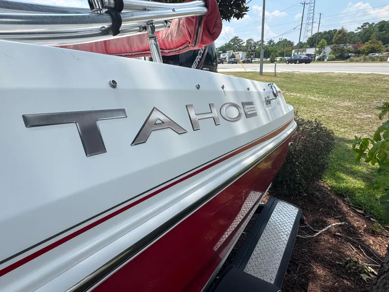 Slide: The Image of 2020 Tahoe 550TS boat, white and red exterior, parked outdoors on a sunny day. - 9