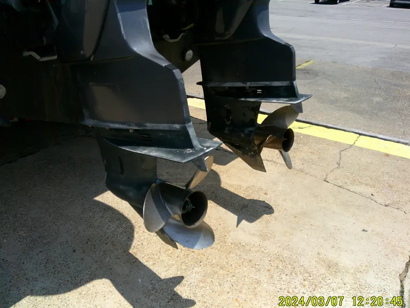 Slide: The Image of Twin propellers of a 2006 McKee Craft FREEDOM TE 28 boat on pavement. - 11