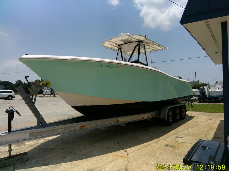 Slide: The Image of 2006 McKee Craft FREEDOM TE 28 boat on trailer, parked outdoors under a clear sky. - 4
