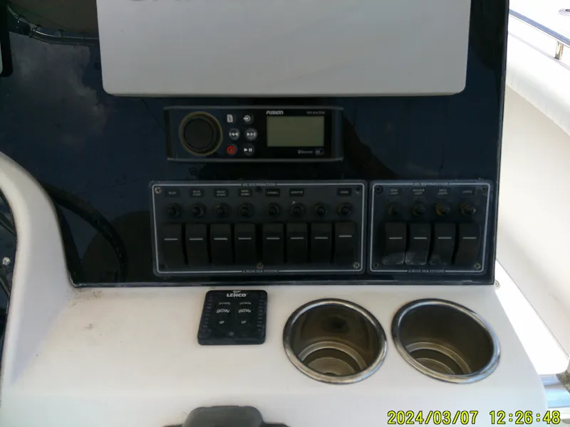 Slide: The Image of Control panel of 2006 McKee Craft FREEDOM TE 28 boat with switches and cup holders. - 43