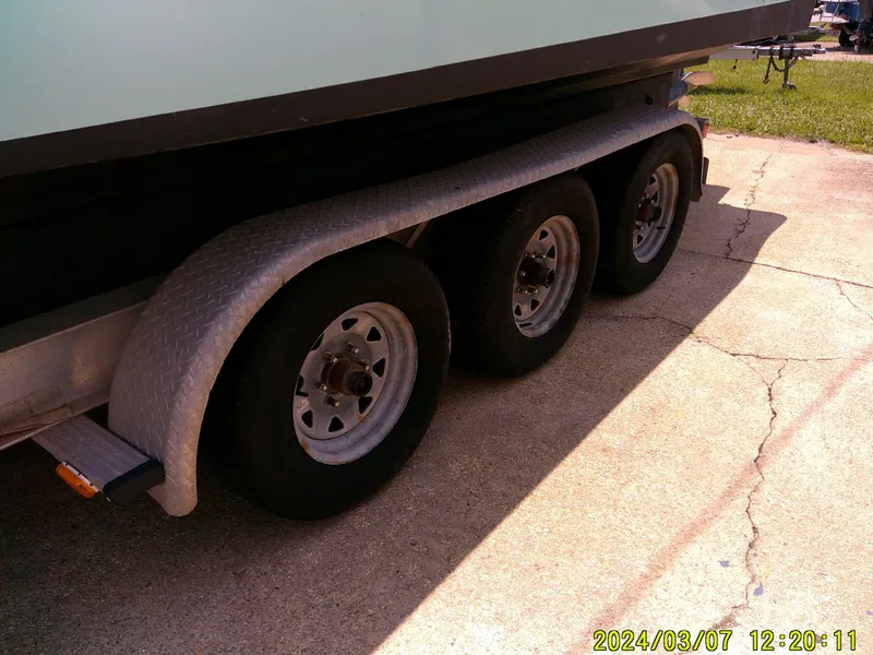 Slide: The Image of Triple-axle trailer of 2006 McKee Craft FREEDOM TE 28 boat on concrete surface. - 6