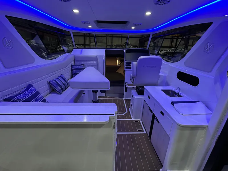 Slide: The Image of Interior of 2025 Extreme Boats 986 Game King, featuring seating, helm, and kitchenette. - 13