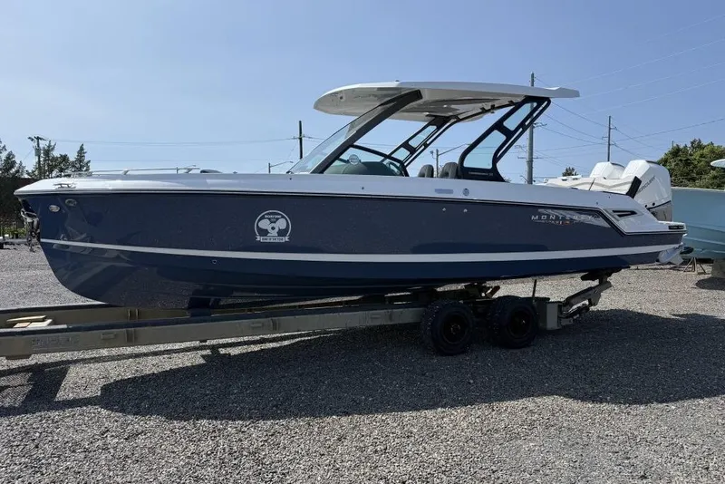 Slide: The Image of 2026 Monterey Elite 30 OB boat displayed indoors with Mercury outboard engine. - 2