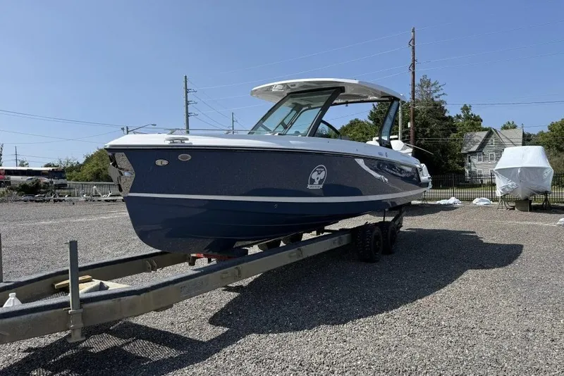Slide: The Image of 2026 Monterey Elite 30 OB boat on trailer, blue hull, outdoor display. - 3