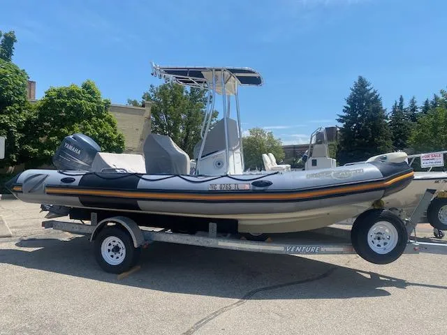 Slide: The Image of 2011 Zodiac Pro Open 650 boat on trailer, featuring Yamaha engine, parked outdoors. - 2