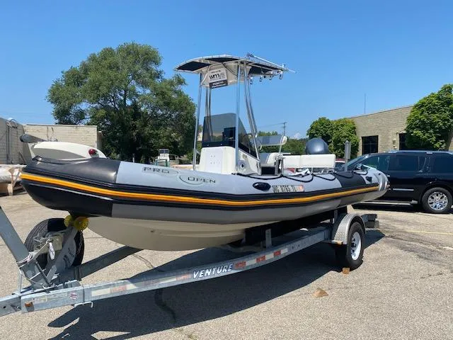 Slide: The Image of 2011 Zodiac Pro Open 650 boat on trailer, parked outdoors under clear blue sky. - 4