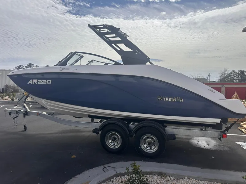 Slide: The Image of 2025 Yamaha AR220 boat on trailer, parked outdoors under cloudy sky. - 28
