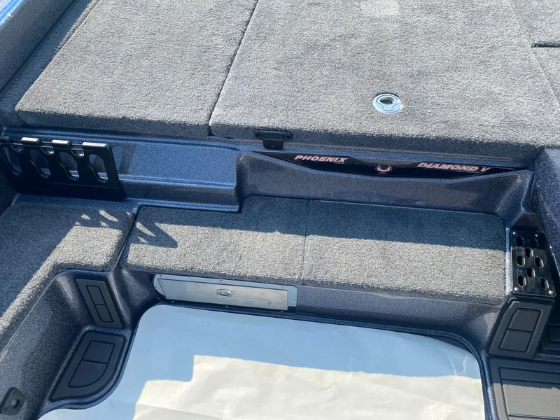 Slide: The Image of 2026 Phoenix 921 2 Elite X boat interior with carpeted deck and storage compartments. - 13