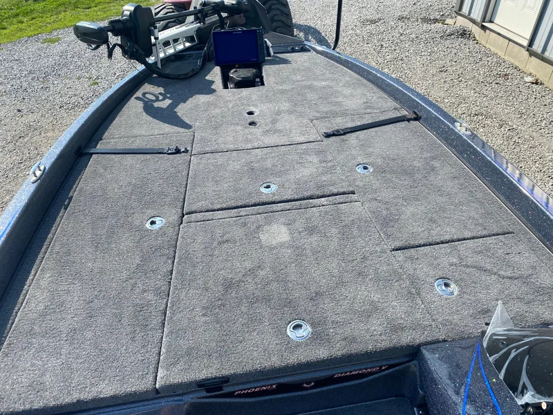 Slide: The Image of 2026 Phoenix 921 2 Elite X boat deck with carpeted surface and fishing equipment. - 15