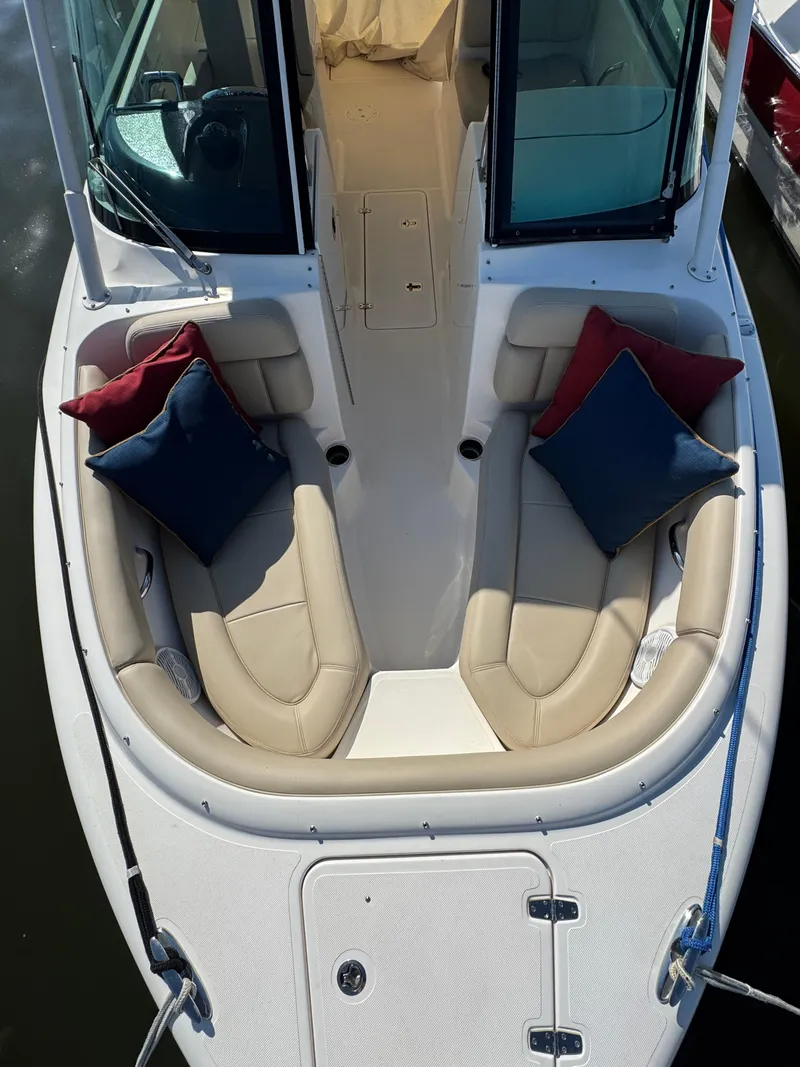 Slide: The Image of 2016 Pursuit DC 265 Dual Console boat with cushioned seating and colorful pillows. - 12
