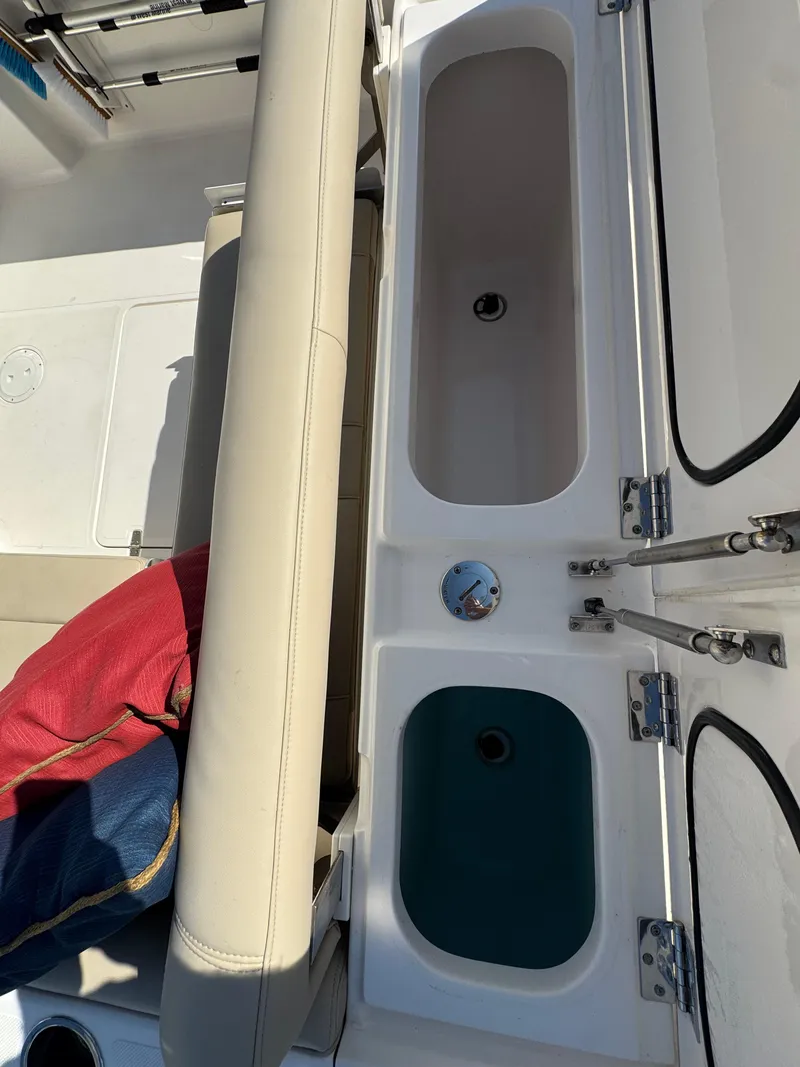 Slide: The Image of 2016 Pursuit DC 265 Dual Console boat interior with seating and storage compartments. - 16