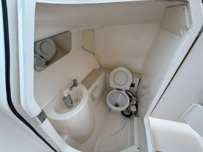 Slide: The Image of 2016 Pursuit DC 265 Dual Console boat bathroom with sink and toilet. - 17