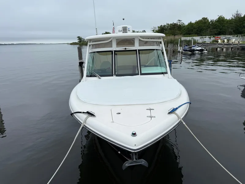 Slide: The Image of 2016 Pursuit DC 265 Dual Console boat docked on calm water. - 3