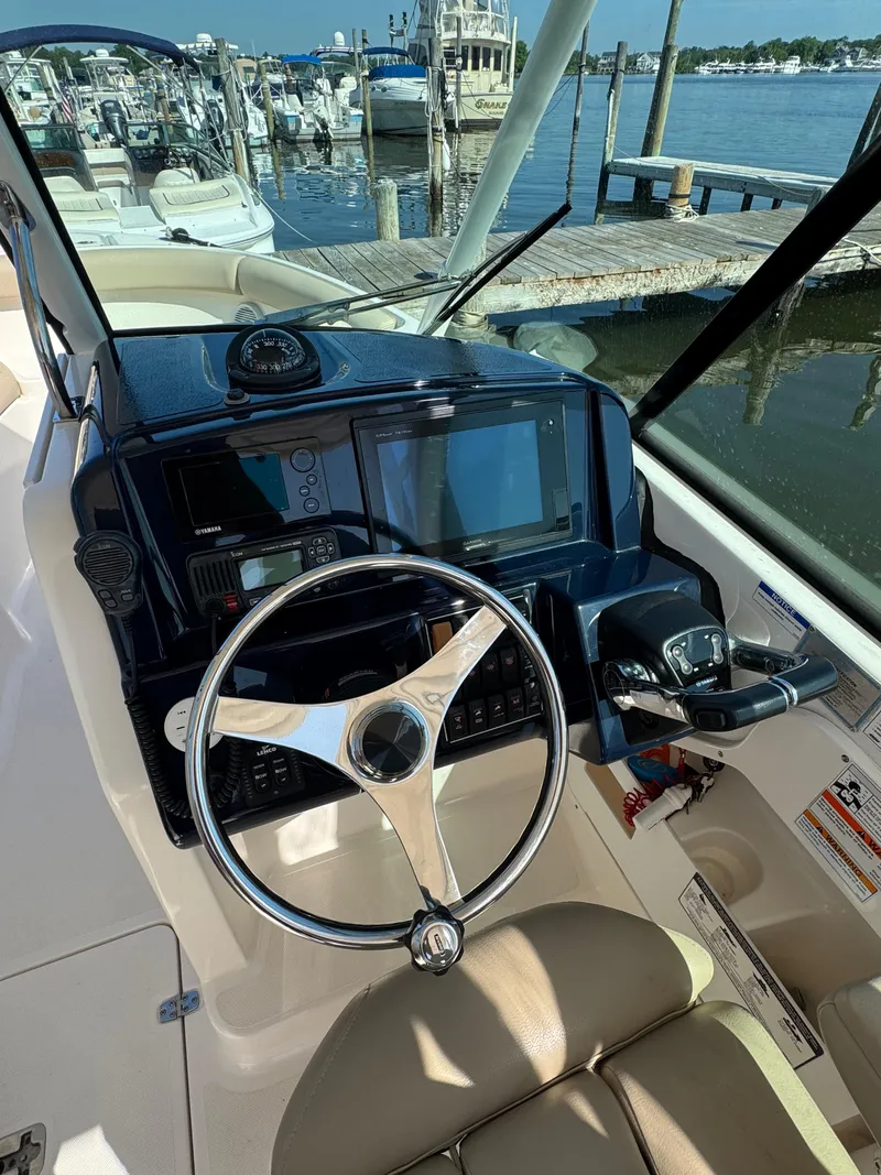 Slide: The Image of 2016 Pursuit DC 265 Dual Console boat dashboard with steering wheel and navigation equipment. - 6
