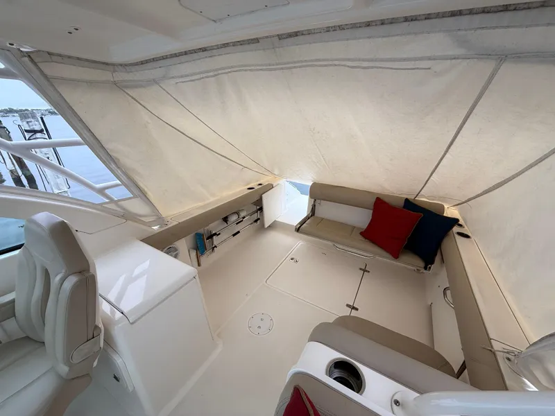 Slide: The Image of 2016 Pursuit DC 265 Dual Console interior with seating, cushions, and covered area. - 8