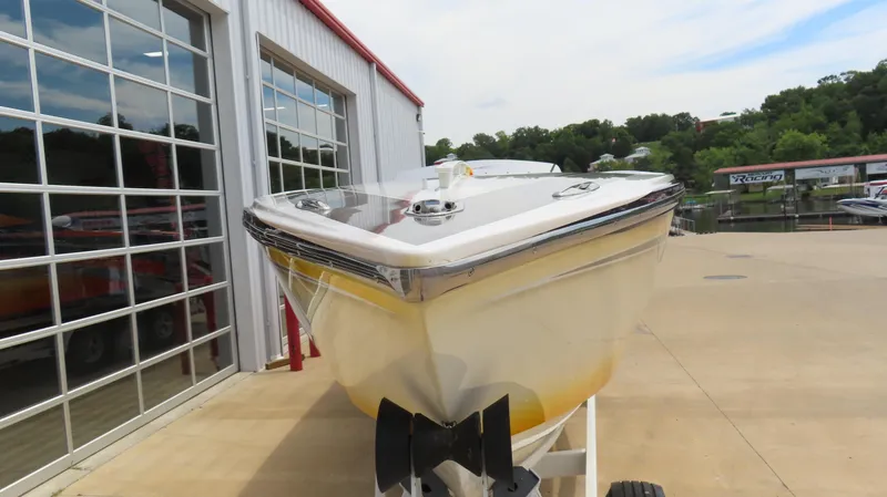 Slide: The Image of 2005 Cigarette 38 Top Gun boat on trailer near a marina and garage. - 11