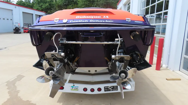 Slide: The Image of 2005 Cigarette 38 Top Gun boat with dual propellers, parked near a garage. - 16