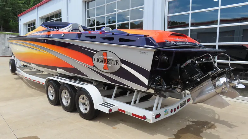 Slide: The Image of 2005 Cigarette 38 Top Gun speedboat on trailer, vibrant orange and purple design. - 17